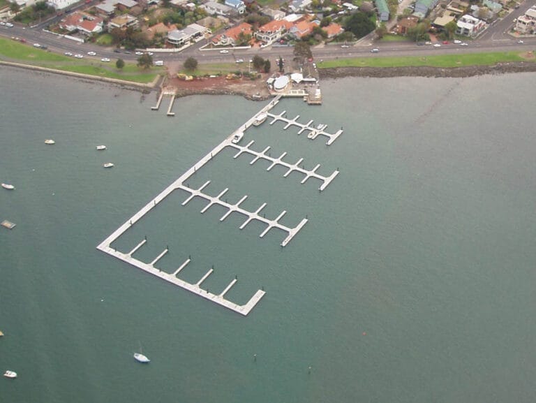 View of Anchorage Marina Williamstown with boats docked along the piers, calm water, and a clear sky.