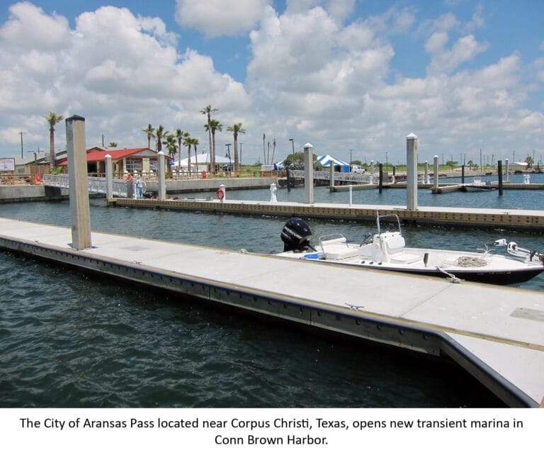 Aerial view of Aransas Pass transient marina with boats docked, surrounded by calm waters and nearby coastal town.