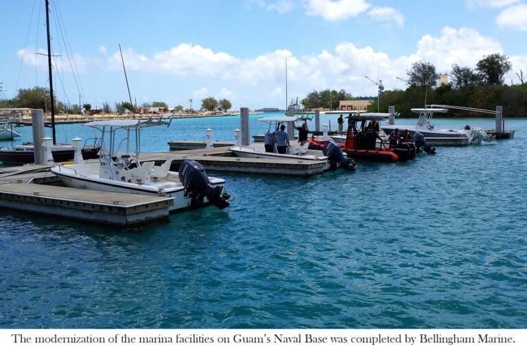 Concrete floating docks at Sumay Cove with boats moored, part of Guam Naval Base marina upgrades.