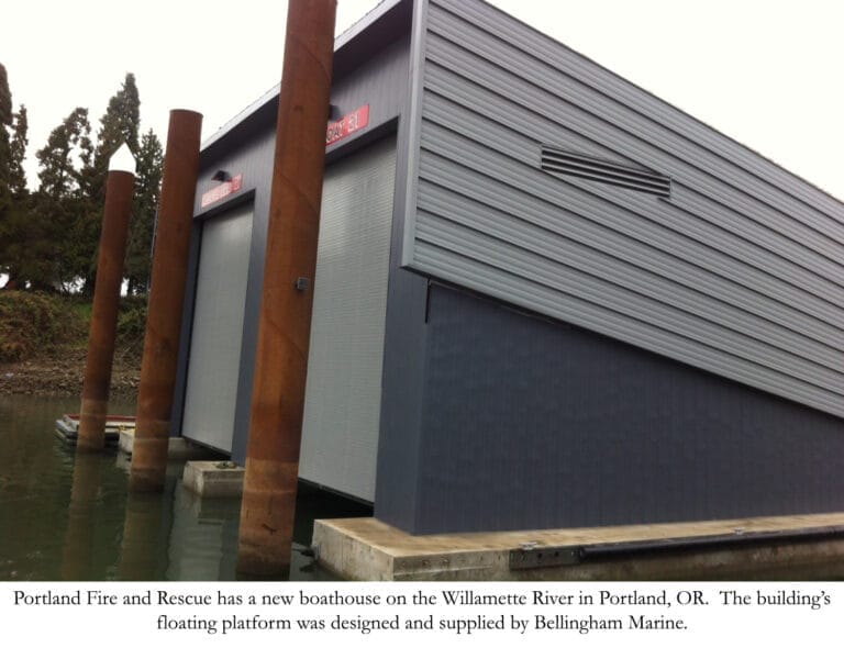 Portland Fire boathouse docks with a modern fire and rescue boat moored, surrounded by calm water and cityscape in the backgr