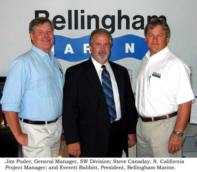 A northern California project manager in a professional setting, wearing a suit and tie, standing in front of a marina backdr