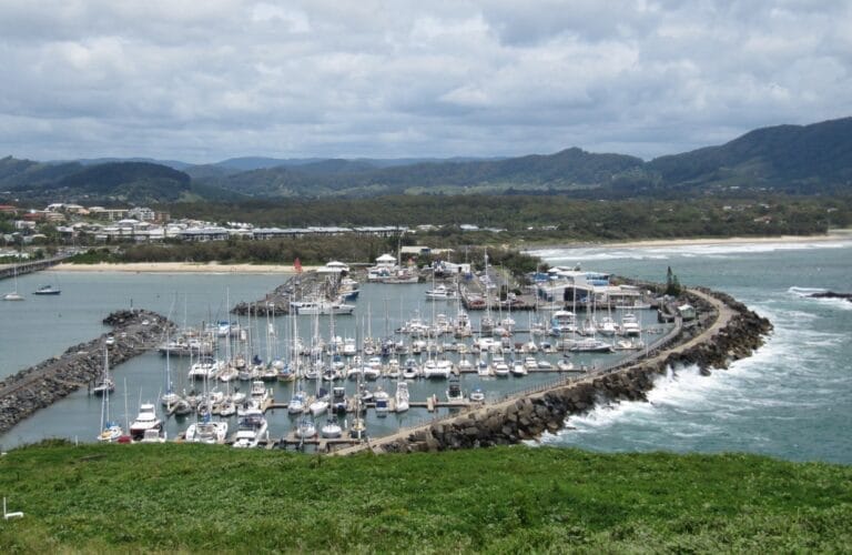 Waves crash over Coffs Harbour’s northern breakwall during a storm, highlighting Coffs Harbour Marina storm repair needs.