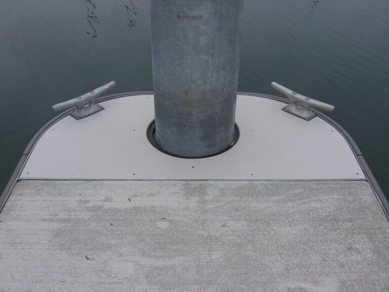 A round finger end with an end pile, part of the Unibolt concrete dock system, set against a marina backdrop.
