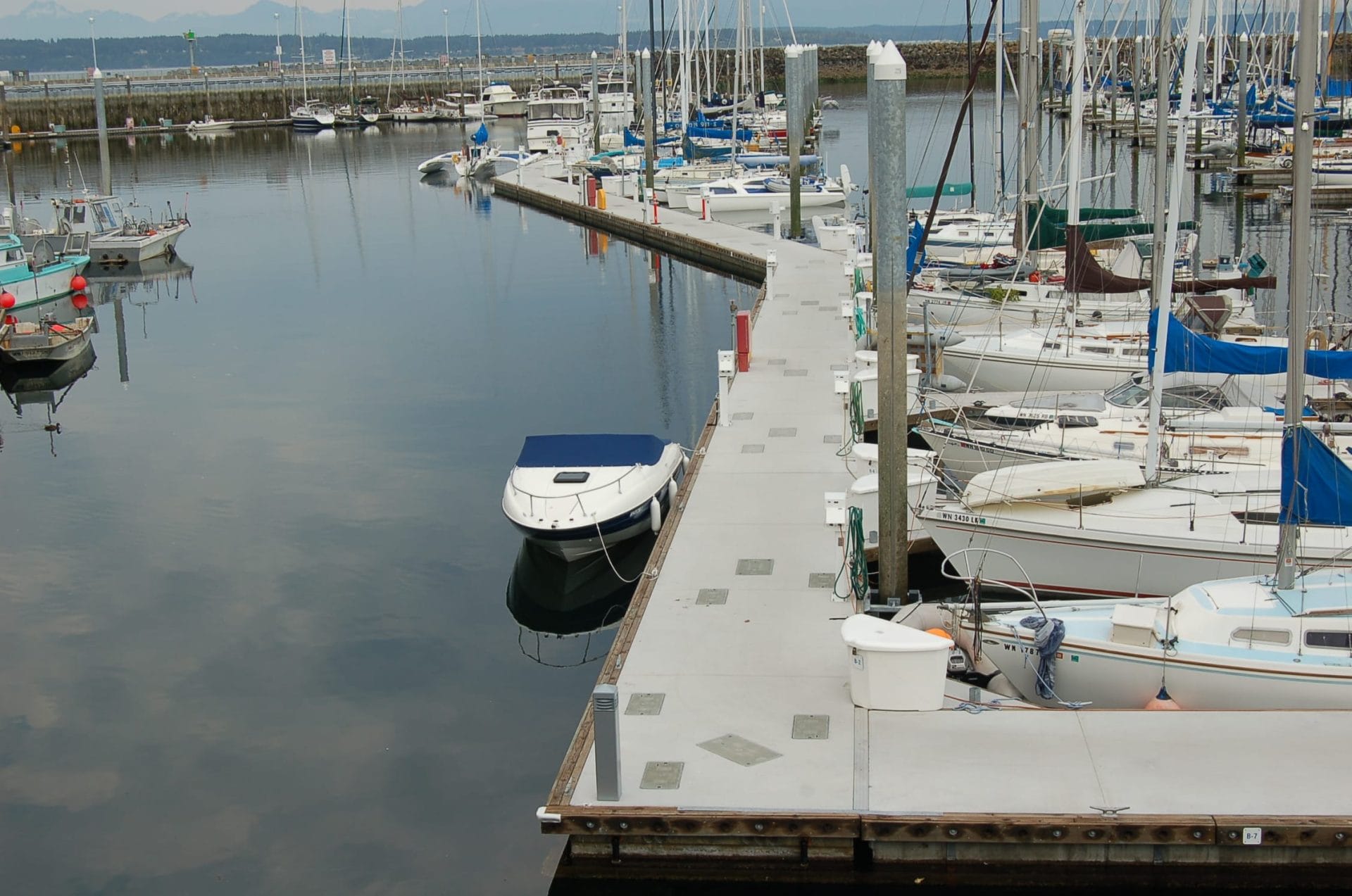 Unibolt concrete dock system featuring a doug fir rub board, with a clear sky and calm water in the background.