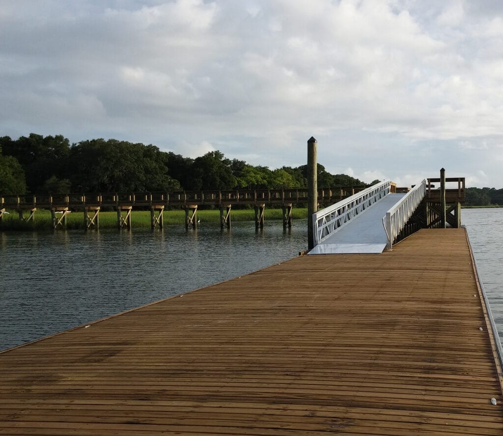 Low-freeboard rowing dock with custom floating dock systems, designed for easy access to watercraft, set against a serene wat