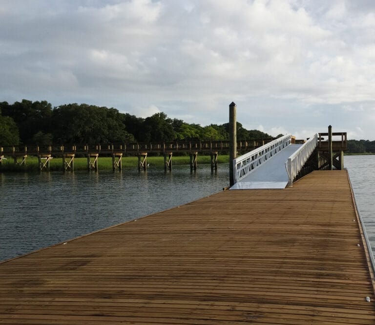 Low-freeboard rowing dock with custom floating dock systems, designed for easy access to watercraft, set against a serene wat
