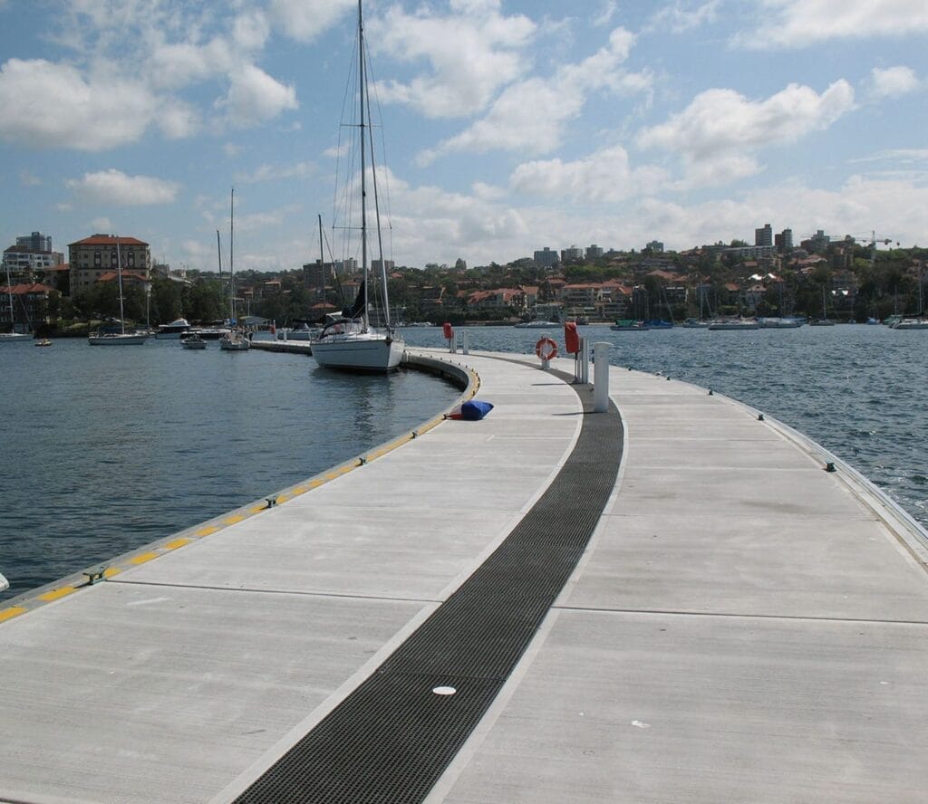 Curved concrete floating wave attenuators with telescoping piles at Royal Sydney Yacht Squadron.