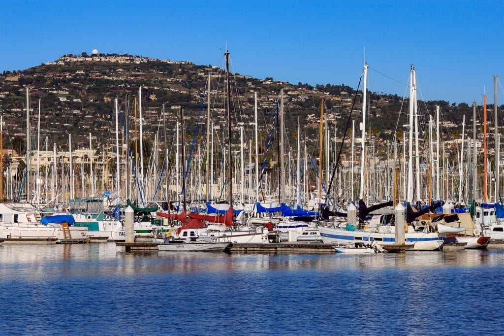 A marina with several boats docked, clear skies, and the Bellingham Marine office locations nearby.