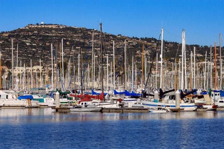 A marina with several boats docked, clear skies, and the Bellingham Marine office locations nearby.