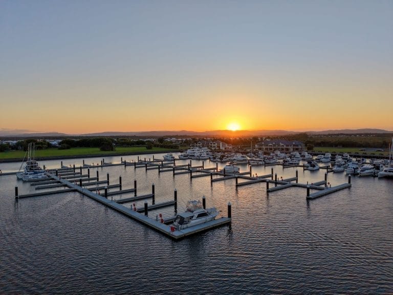 Aerial view of Calypso Bay Marina expansion showing new docks and boats, surrounded by clear blue water and lush greenery.